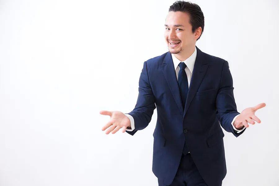 両手を広げるスーツの男