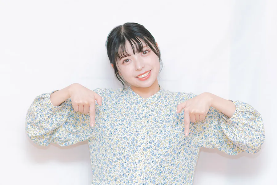 下を指さす女性