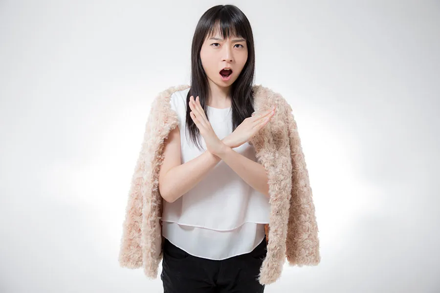 手で×を作る女性