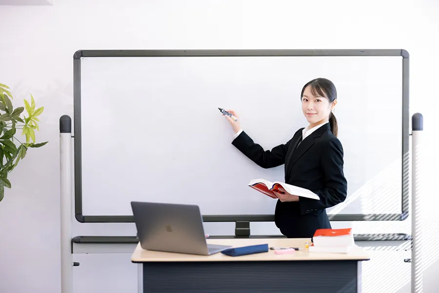 ホワイトボードにメモをする女性